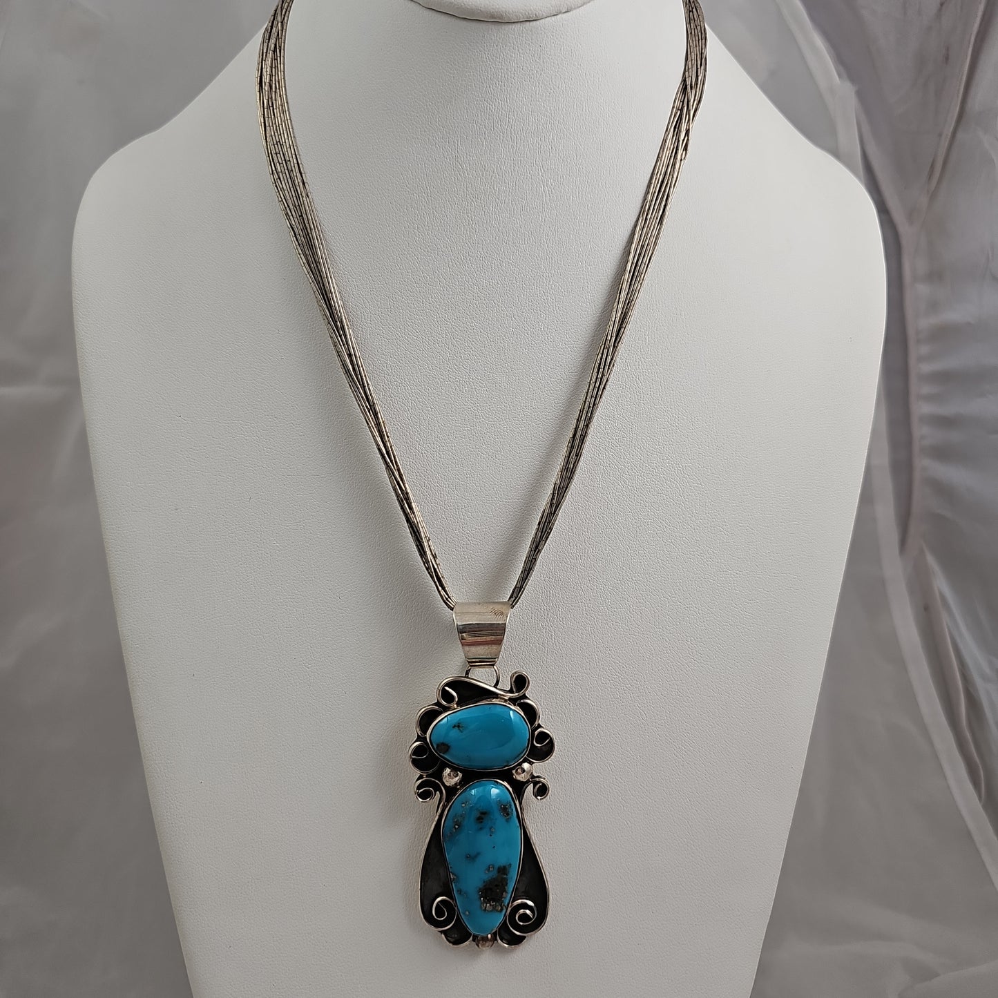 Chimney Butte turquoise scroll pendant on liquid silver chain.