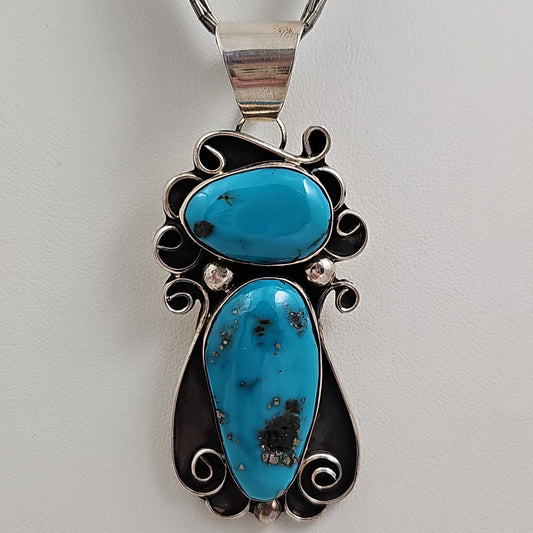 Chimney Butte turquoise scroll pendant on liquid silver chain.